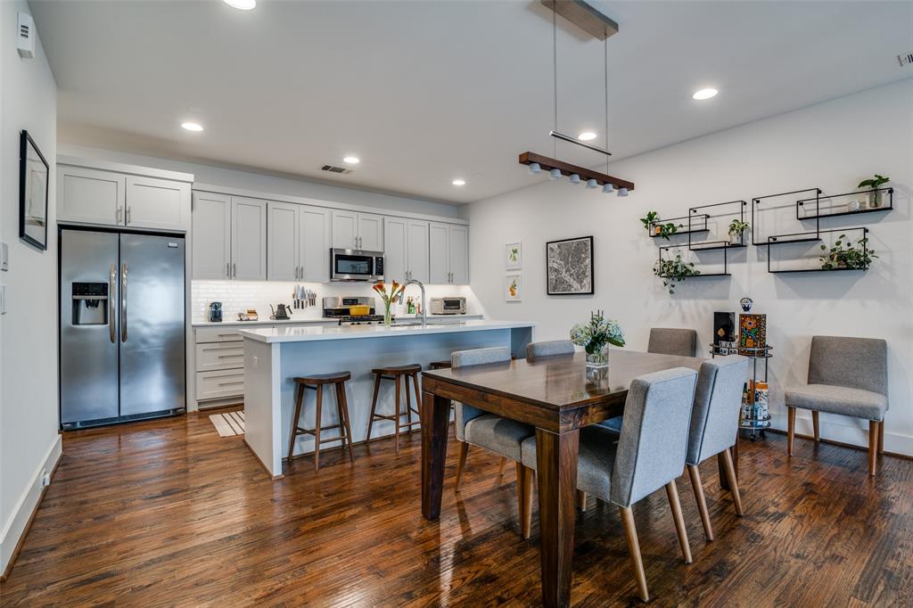5602 Lindell Avenue, Unit B Dallas, TX 75206 - Photo 10 of 29 a kitchen with stainless steel appliances granite countertop a refrigerator a stove a sink a dining table and chairs with wooden floor