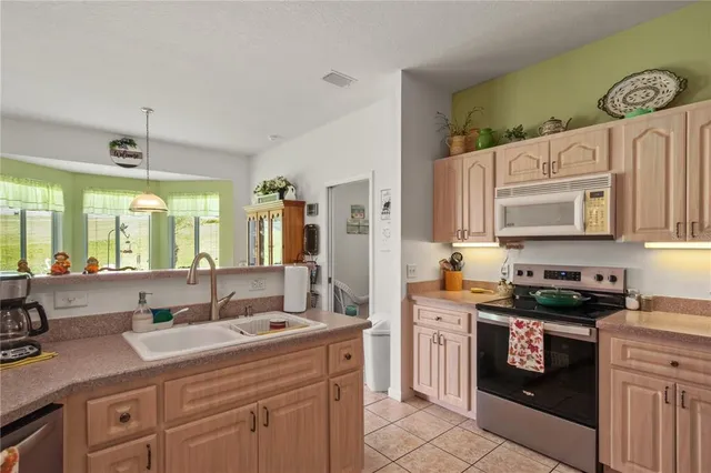 a kitchen with stainless steel appliances granite countertop a sink a stove and a refrigerator