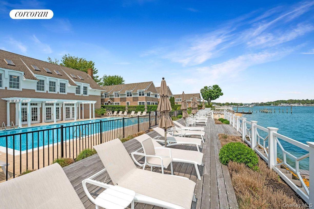 49 Canoe Place Road, Unit 312 Hampton Bays, NY 11946 - Photo 12 of 12 a view of a chairs and table on the balcony