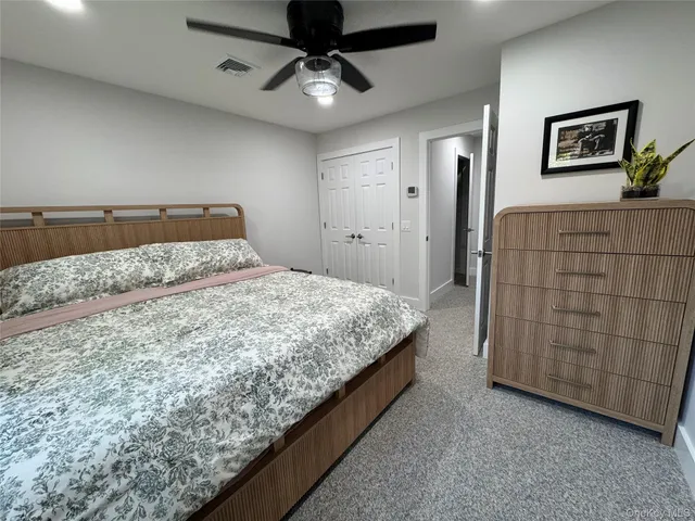 a bedroom with a bed and painting on the wall