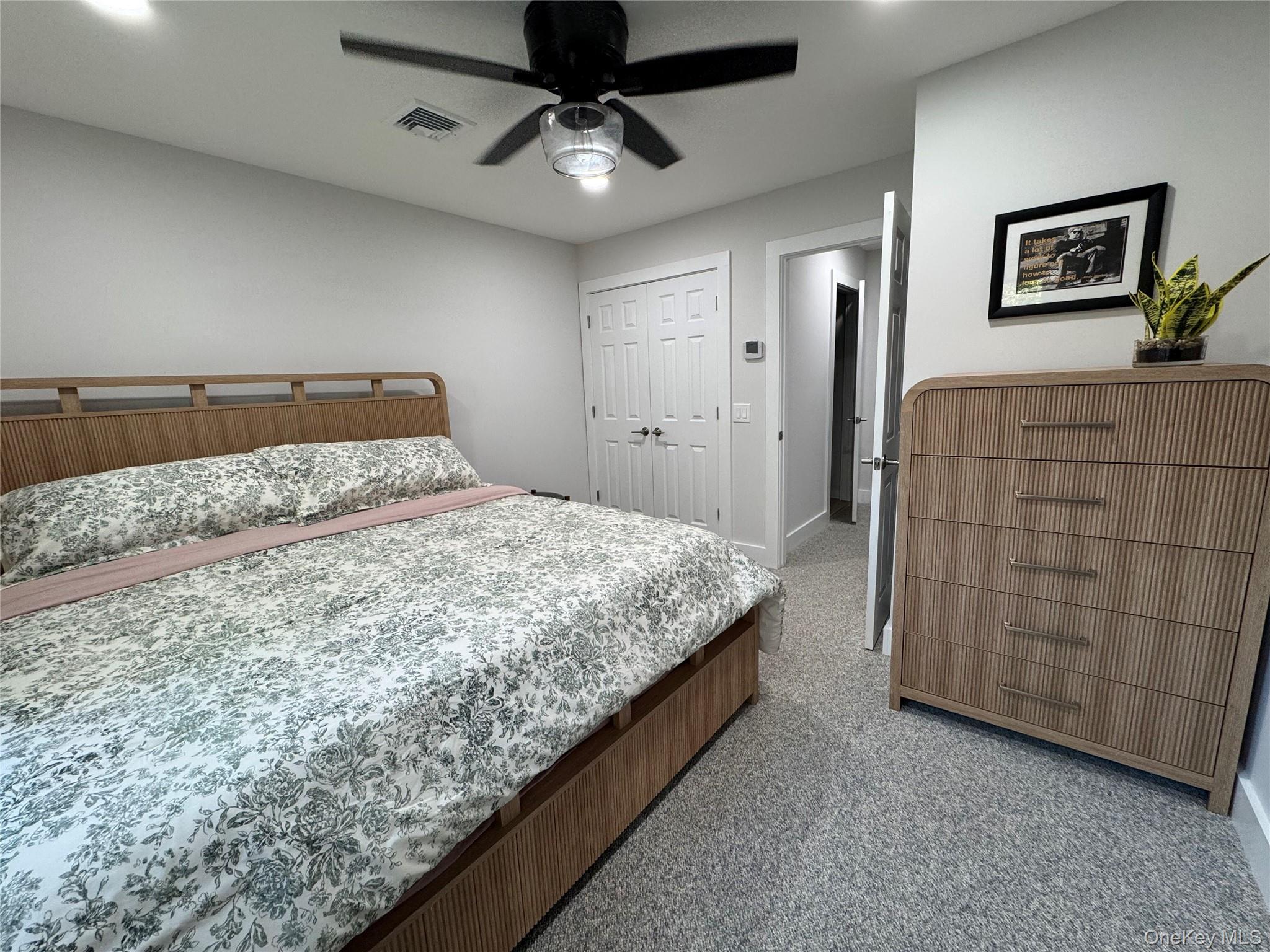 49 Canoe Place Road, Unit 312 Hampton Bays, NY 11946 - Photo 2 of 12 a bedroom with a bed and painting on the wall