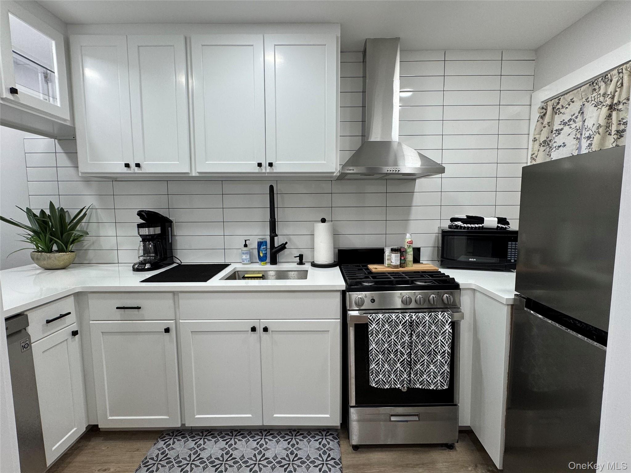 49 Canoe Place Road, Unit 312 Hampton Bays, NY 11946 - Photo 7 of 12 a kitchen with appliances cabinets and a counter top space