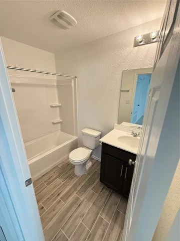 a view of an empty room with wooden floor and staircase