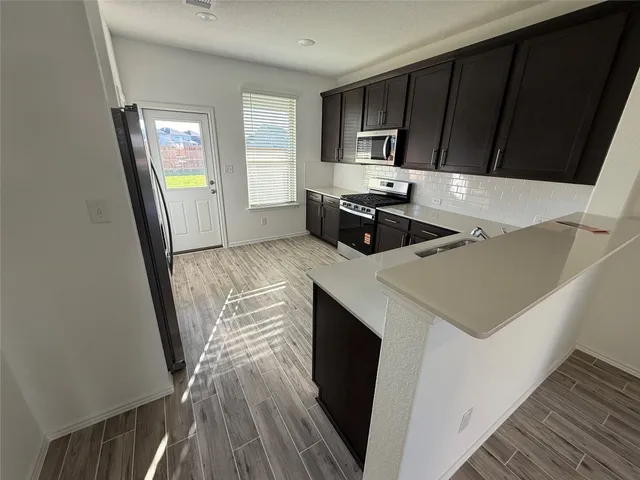 a view of a hallway with wooden floor and staircase