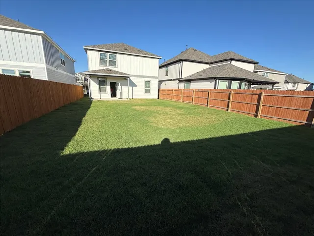 a view of a refrigerator in kitchen and an empty room