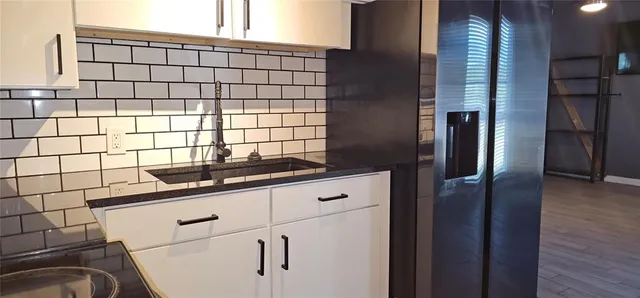 a kitchen with granite countertop a sink and a refrigerator