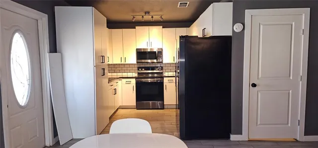 a kitchen with stainless steel appliances granite countertop a refrigerator and a stove