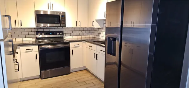 a kitchen with stainless steel appliances granite countertop a stove and a refrigerator