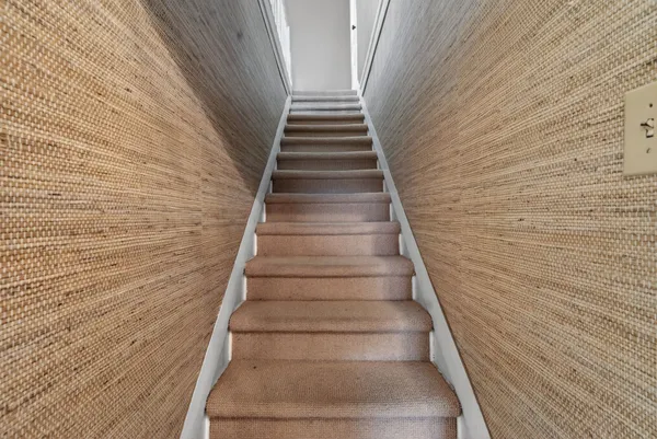 an empty room with chandelier fan and windows