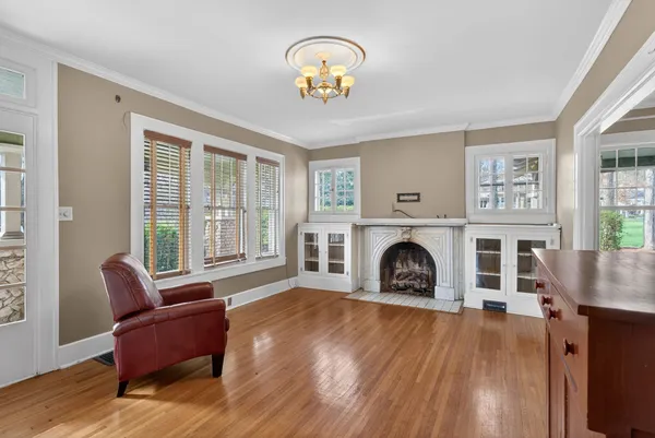 a view of an empty room with wooden floor and windows