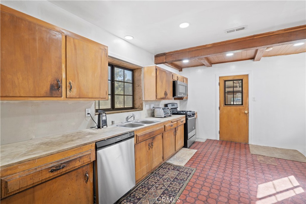 24811 Meadview Avenue Newhall, CA 91321 - Photo 28 of 73 a large kitchen with stainless steel appliances granite countertop a sink and dishwasher stove with wooden floor