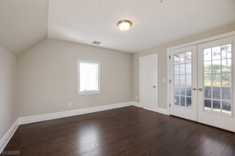 174 Main Street, Unit 2 Madison, NJ 07940 - Photo 12 of 18 an empty room with wooden floor and windows