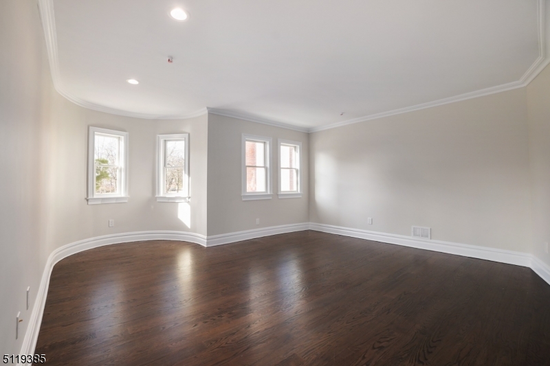 174 Main Street, Unit 2 Madison, NJ 07940 - Photo 2 of 18 a view of an empty room with wooden floor and window