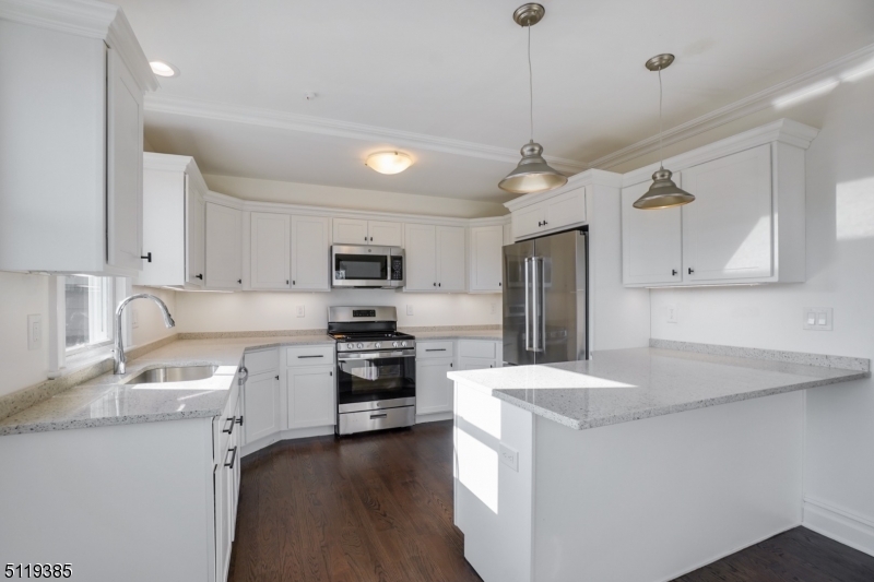 174 Main Street, Unit 2 Madison, NJ 07940 - Photo 4 of 18 a kitchen with stainless steel appliances kitchen island granite countertop a sink a stove a refrigerator and island with wooden floor