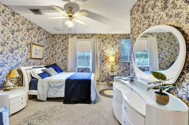 a spacious bedroom with a bed and ceiling fan