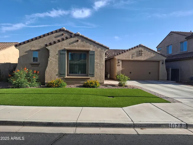 a front view of a house with a garden and plants