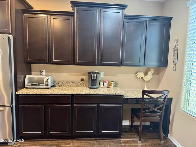 a room with granite countertop a sink cabinets and wooden floor
