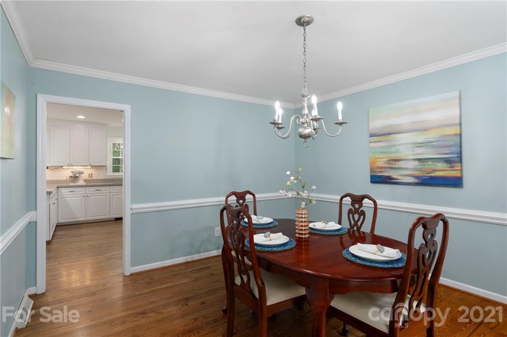 224 Raintree Drive Matthews, NC 28104 - Photo 11 of 48 a view of a dining room with furniture a chandelier and wooden floor