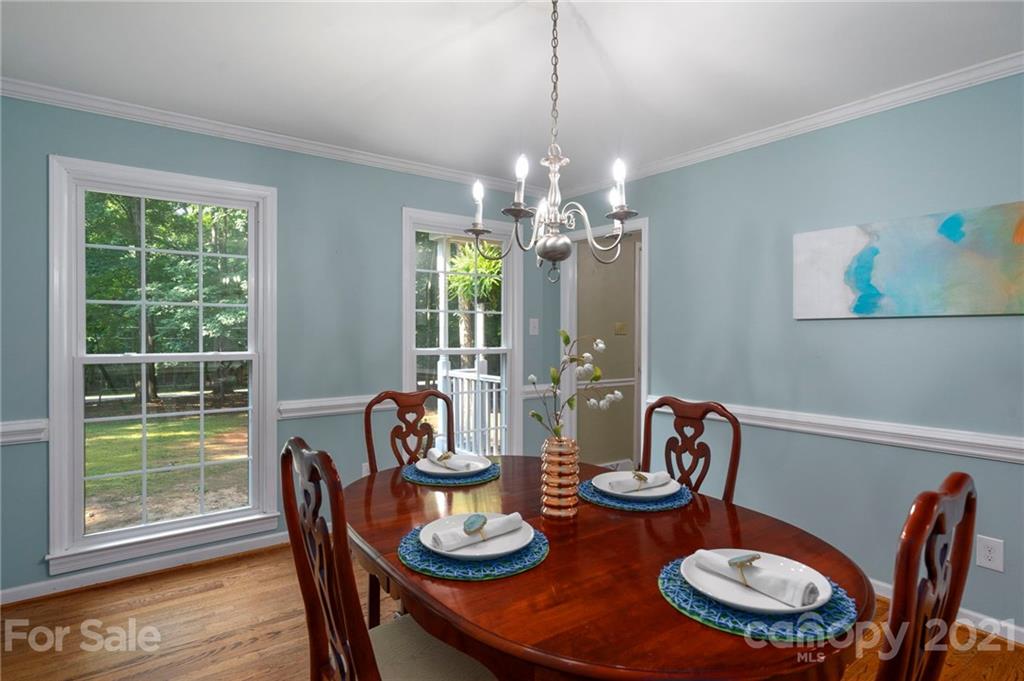 224 Raintree Drive Matthews, NC 28104 - Photo 12 of 48 a view of a dining room with furniture a chandelier and wooden floor