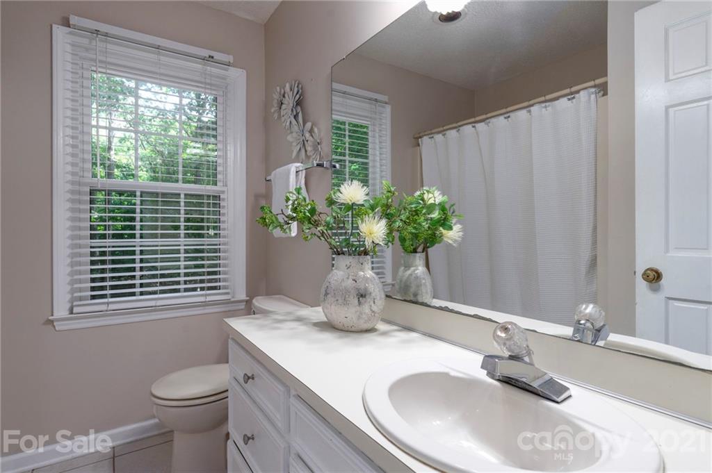 224 Raintree Drive Matthews, NC 28104 - Photo 27 of 48 a bathroom with a granite countertop sink a toilet and a mirror