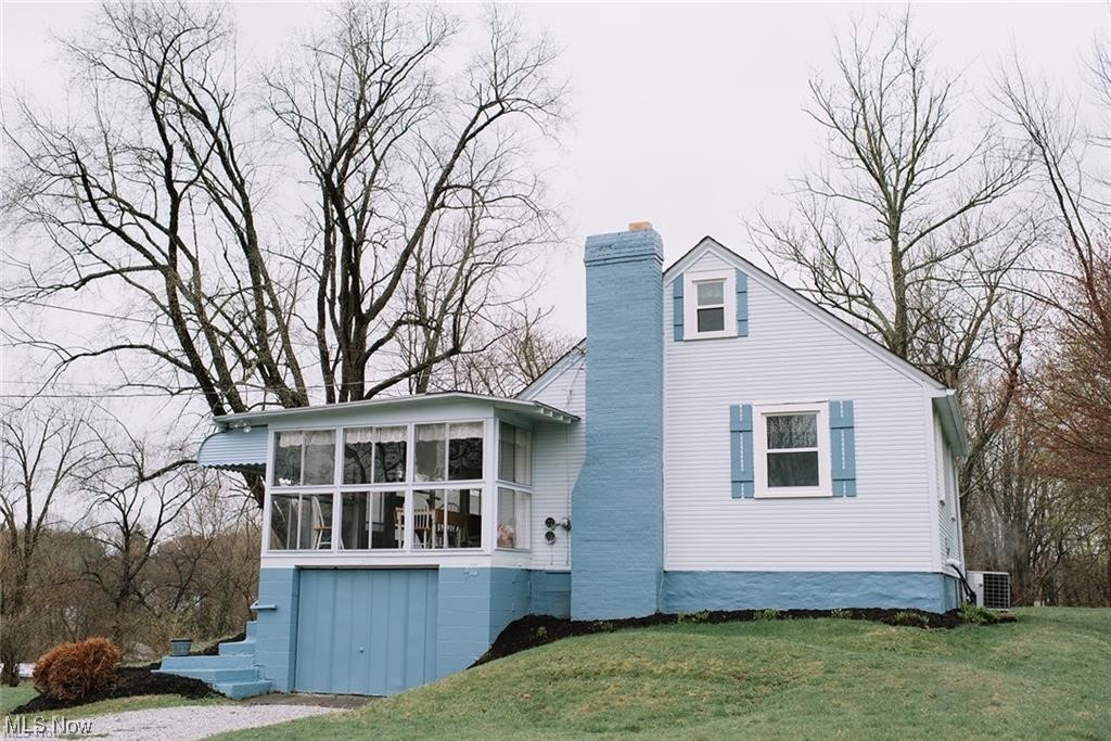 1200 Swartz Road Akron, OH 44306 - Photo 2 of 24 View of home's exterior featuring a sunroom, central air condition unit.