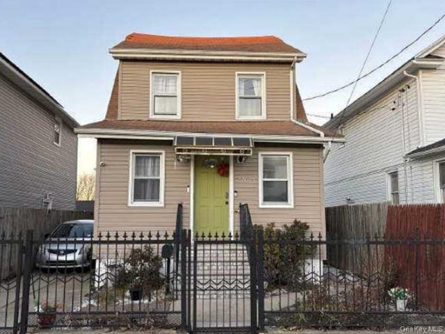 220-25 134th Road Queens, NY 11413 - Photo 1 of 1 View of front of property featuring a fenced front yard and a gate