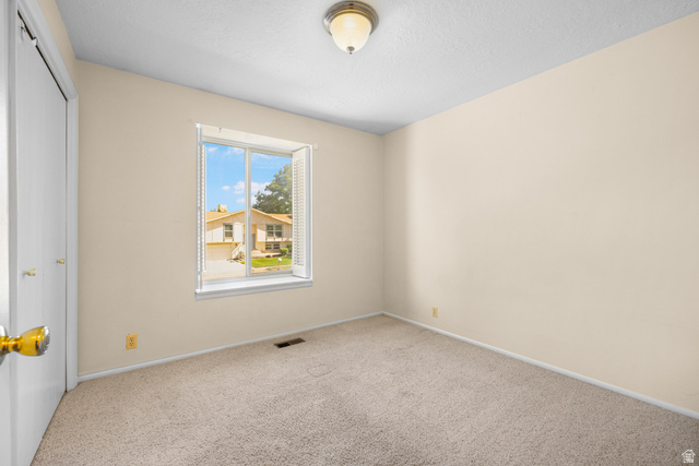 2088 Falcon Way Sandy, UT 84093 - Photo 14 of 46 Carpeted interior space featuring a window with white louvered blinds, light-colored walls, a ceiling-mounted light fixture, and a white bi-fold closet door