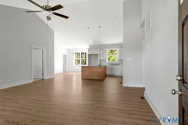 a view of an empty room with a window and wooden floor