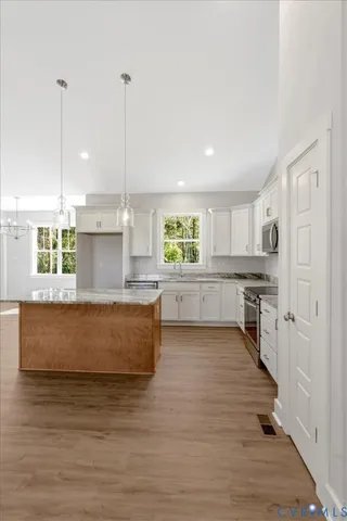 a large kitchen with kitchen island a sink stainless steel appliances and cabinets