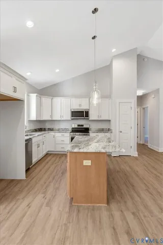 a large kitchen with granite countertop a stove top oven a sink a counter space and cabinets