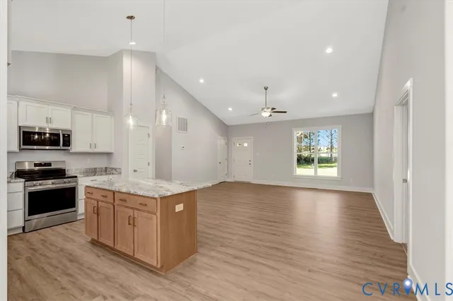 a large kitchen with stainless steel appliances granite countertop a stove and a sink