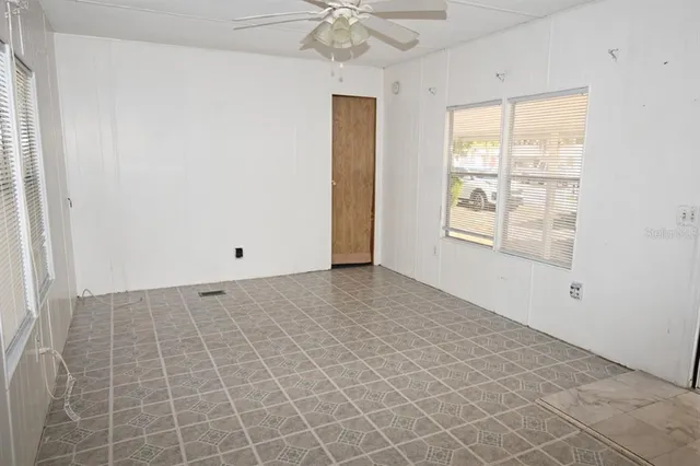 a view of kitchen with refrigerator and white cabinets