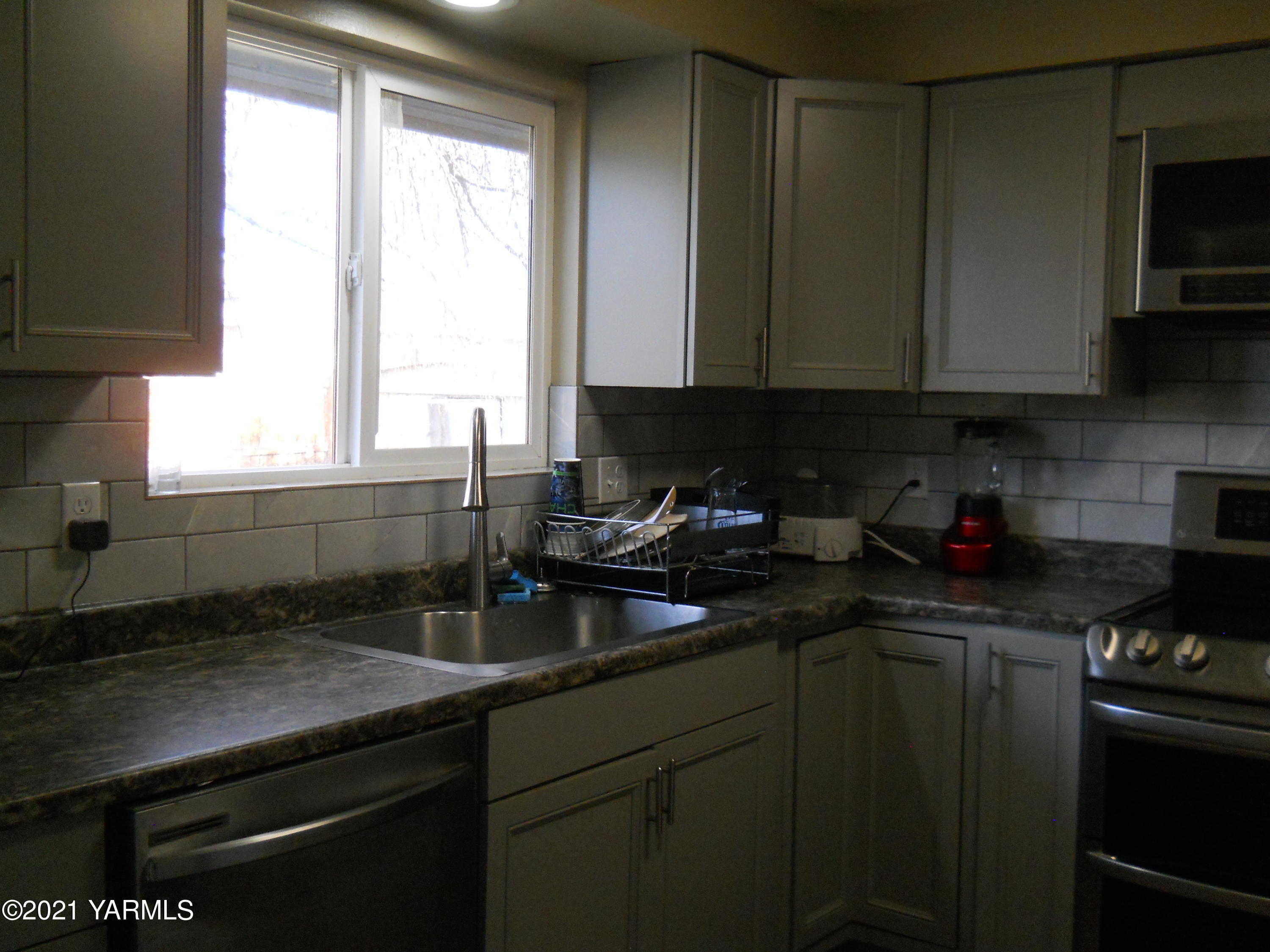107 East Bonnieview Road Grandview, WA 98930 - Photo 7 of 24 a kitchen with a sink cabinets and window