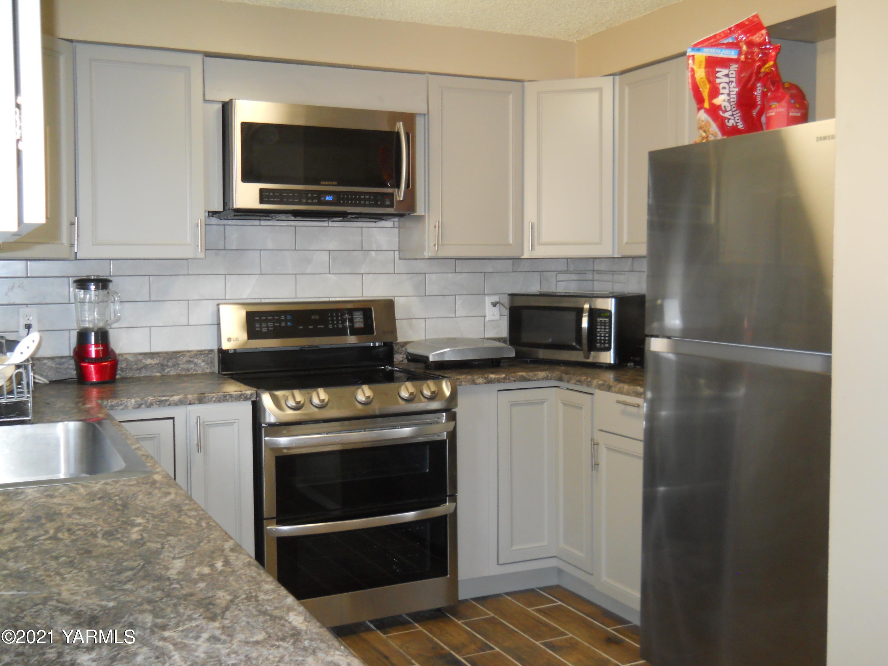 107 East Bonnieview Road Grandview, WA 98930 - Photo 8 of 24 a kitchen with a refrigerator and a stove top oven