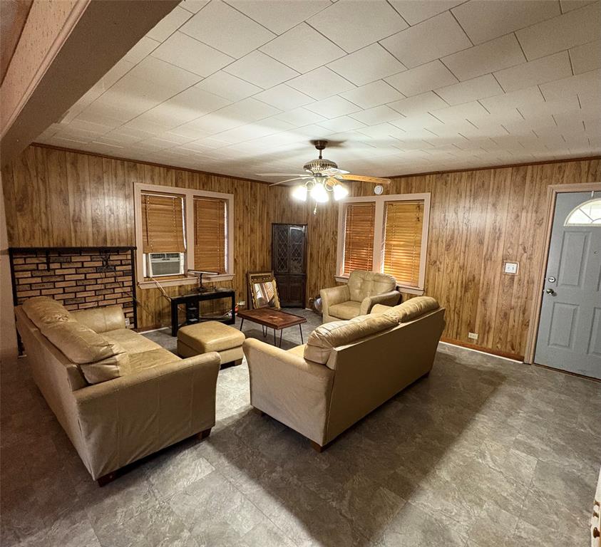407 North Lane Street Decatur, TX 76234 - Photo 8 of 22 Living area with wood walls, ceiling fan, and cooling unit