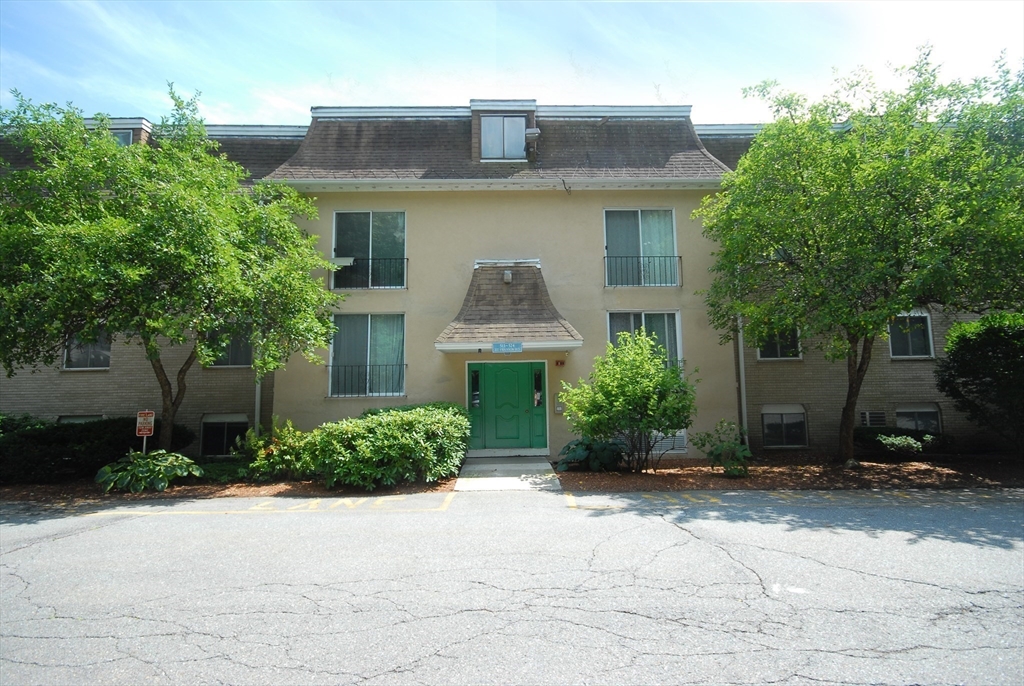 202 Swanson Road, Unit 515 Boxborough, MA 01719 - Photo 14 of 17 a front view of a house with a yard and trees