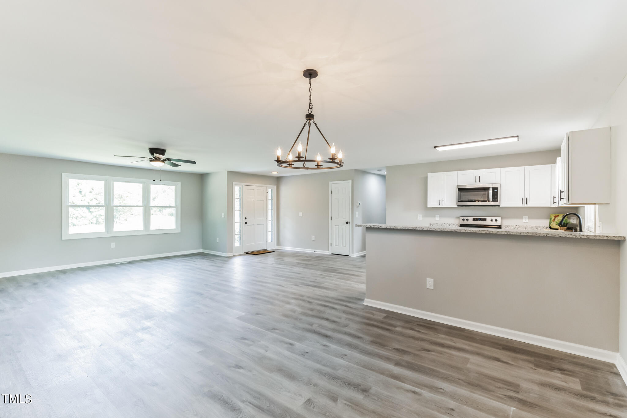 2395 Highway 210 Garland, NC 28441 - Photo 8 of 30 an empty room with wooden floor kitchen view and windows