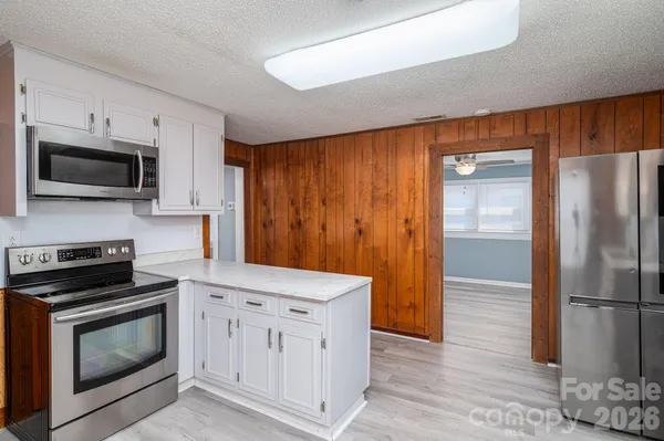 a kitchen with white cabinets and stainless steel appliances