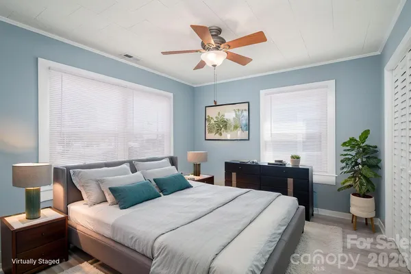 a bedroom with a bed and a potted plant
