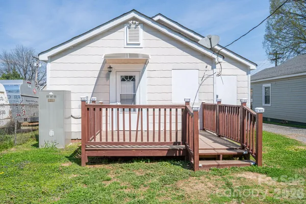 a view of a small yard in front of a house with wooden fence