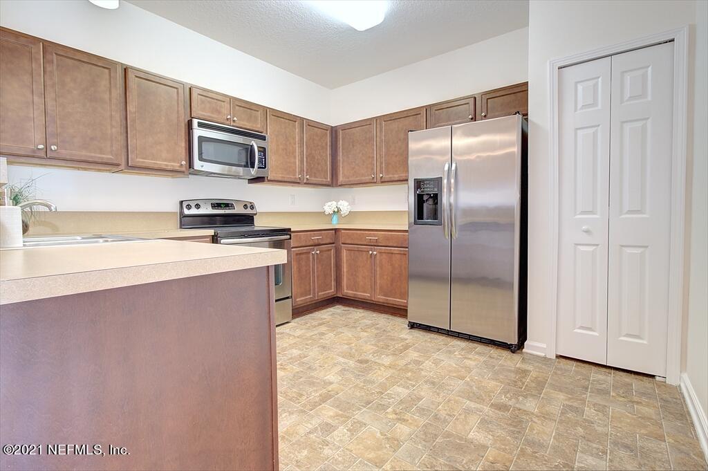 2211 Golden Lake Loop St. Augustine, FL 32084 - Photo 6 of 29 a kitchen with stainless steel appliances granite countertop a refrigerator a stove a sink and white cabinets