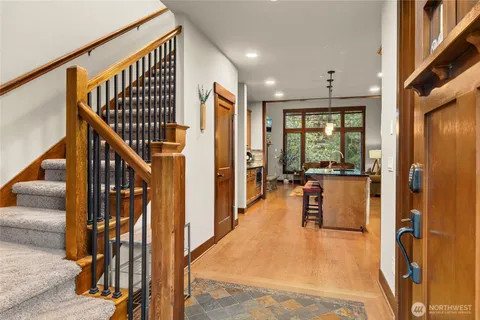 a view of a hallway with wooden floor and staircase