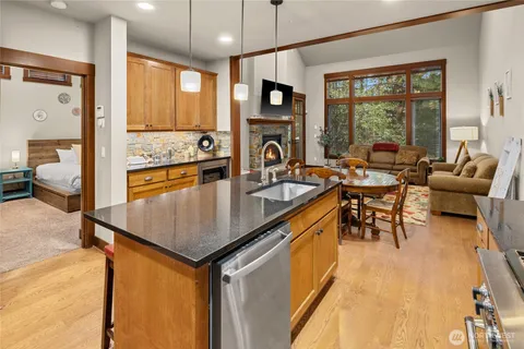 a kitchen with sink a refrigerator and chairs