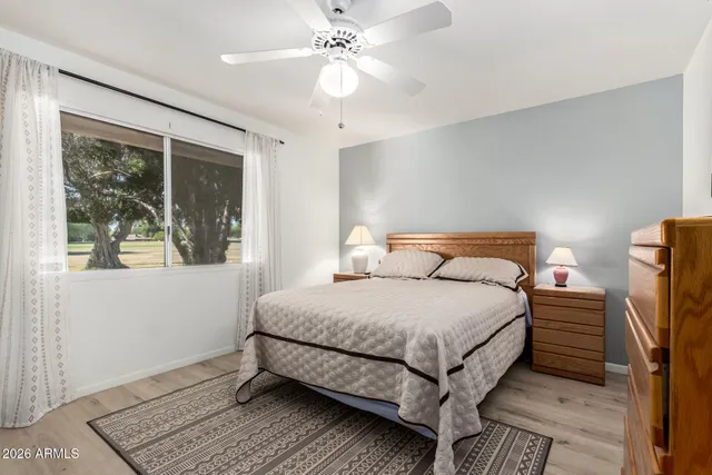 a kitchen with stainless steel appliances a stove top oven a refrigerator a sink and white cabinets with wooden floor