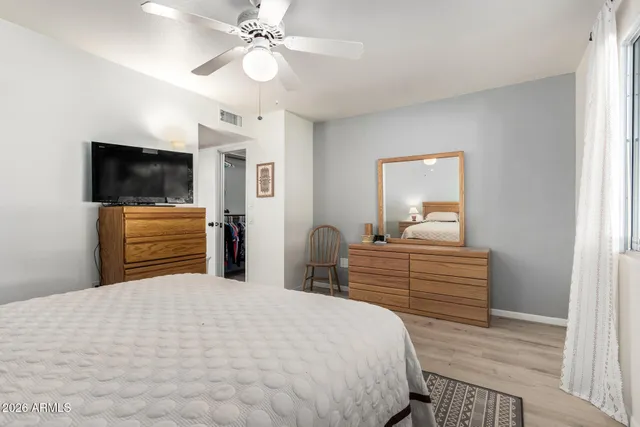 a bedroom with a bed lamp and a large window