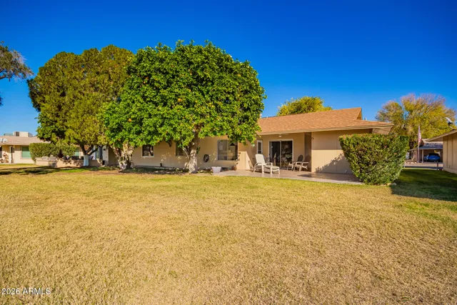 a view of a house with backyard sitting area and garden