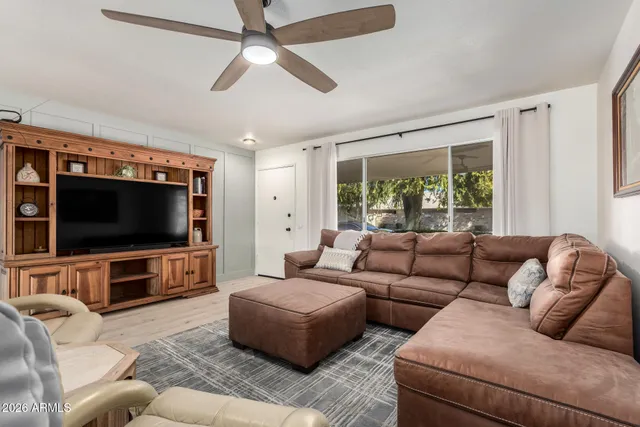 a living room with furniture a large window and a flat screen tv