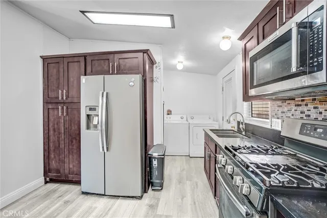 a kitchen with stainless steel appliances granite countertop a refrigerator stove and sink