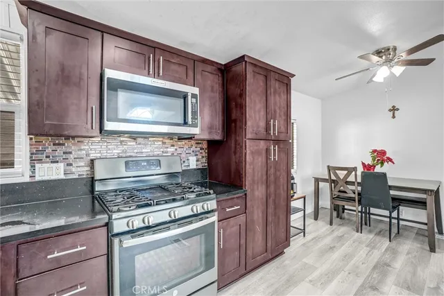 a kitchen with a stove a refrigerator and cabinets