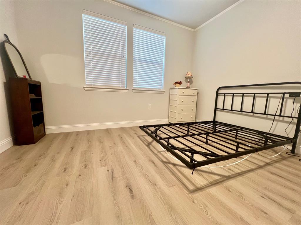 651 Watters Road, Unit 7101 Allen, TX 75013 - Photo 15 of 25 Bedroom with wood finished floors, lofted ceiling, and crown molding